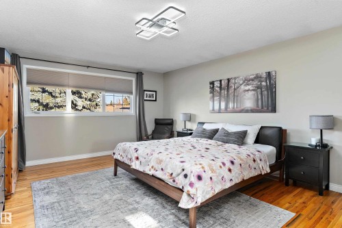 Bedroom with light wood-type flooring and a textured ceiling - 317 Grand Meadow Crescent, Edmonton, AB - Indoor Photo Showing Bedroom