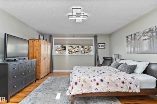 Bedroom with a textured ceiling and light wood finished floors - 317 Grand Meadow Crescent, Edmonton, AB - Indoor Photo Showing Bedroom