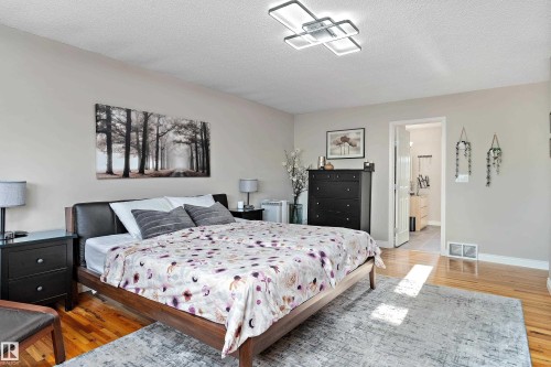 Bedroom with light wood-style flooring and a textured ceiling - 317 Grand Meadow Crescent, Edmonton, AB - Indoor Photo Showing Bedroom