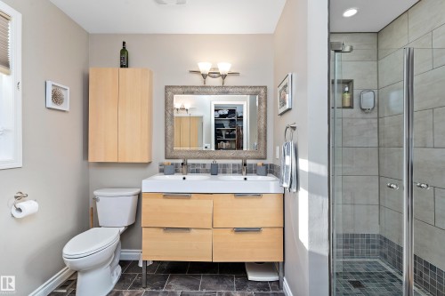 Full bath featuring a stall shower, double vanity, and a spacious closet - 317 Grand Meadow Crescent, Edmonton, AB - Indoor Photo Showing Bathroom