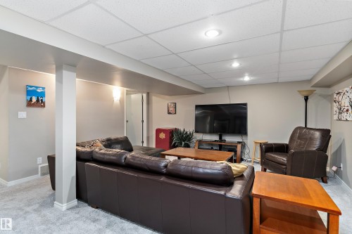 Living room with light carpet and a drop ceiling - 317 Grand Meadow Crescent, Edmonton, AB - Indoor Photo Showing Basement
