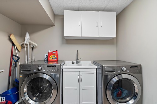 Laundry area with cabinet space and washer and clothes dryer - 317 Grand Meadow Crescent, Edmonton, AB - Indoor Photo Showing Laundry Room