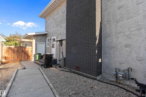 View of side of home featuring brick siding, stucco siding, a gate, and crawl space - 317 Grand Meadow Crescent, Edmonton, AB - Outdoor With Exterior
