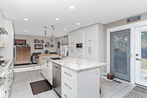 Kitchen with white cabinetry, light stone countertops, pendant lighting, a center island with sink, and recessed lighting - 317 Grand Meadow Crescent, Edmonton, AB - Indoor Photo Showing Kitchen With Upgraded Kitchen