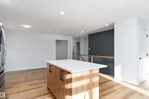 Kitchen with a center island, recessed lighting, light wood-type flooring, wood finish cabinetry, and freestanding refrigerator - 17116 81 Avenue, Edmonton, AB - Indoor