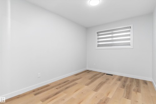 Unfurnished room featuring light wood-type flooring and baseboards - 17116 81 Avenue, Edmonton, AB - Indoor Photo Showing Other Room