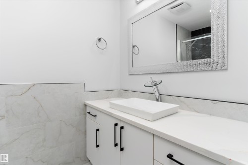 Full bathroom featuring vanity, a shower stall, tile walls, and wainscoting - 17116 81 Avenue, Edmonton, AB - Indoor Photo Showing Bathroom