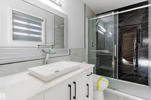 Full bath with vanity, a marble finish shower, and tile walls - 17116 81 Avenue, Edmonton, AB - Indoor Photo Showing Bathroom