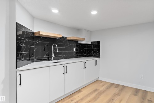 Kitchen with open shelves, light wood-type flooring, white cabinetry, and backsplash - 17116 81 Avenue, Edmonton, AB - Indoor