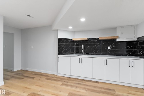 Kitchen featuring white cabinets, open shelves, light wood-type flooring, decorative backsplash, and recessed lighting - 17116 81 Avenue, Edmonton, AB - Indoor Photo Showing Other Room