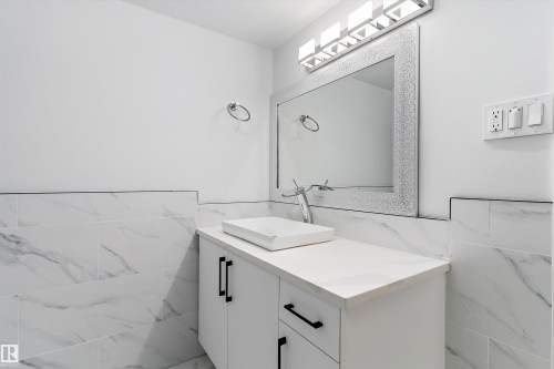 Bathroom with tile walls, a wainscoted wall, and vanity - 17116 81 Avenue, Edmonton, AB - Indoor Photo Showing Bathroom