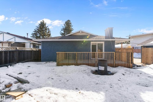 Snow covered back of property featuring a chimney, a deck, stucco siding, and roof with shingles - 17116 81 Avenue, Edmonton, AB - Outdoor