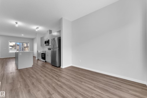 Kitchen with light countertops, stainless steel appliances, a center island, and light wood-style flooring - 1235 16 Avenue, Edmonton, AB - Indoor Photo Showing Kitchen