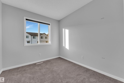 Unfurnished room with light carpet and a textured ceiling - 1235 16 Avenue, Edmonton, AB - Indoor Photo Showing Other Room