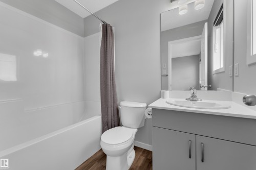 Full bathroom with shower / bath combination with curtain, vanity, and dark wood-style floors - 1235 16 Avenue, Edmonton, AB - Indoor Photo Showing Bathroom