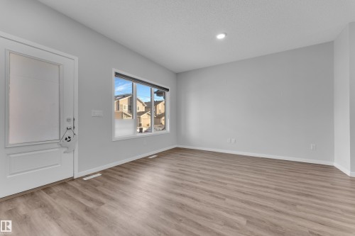 Foyer with light wood finished floors and a textured ceiling - 1235 16 Avenue, Edmonton, AB - Indoor Photo Showing Other Room