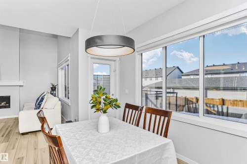 Dining space featuring light wood-style floors and a fireplace - 3108 158 Street, Edmonton, AB - Indoor Photo Showing Dining Room