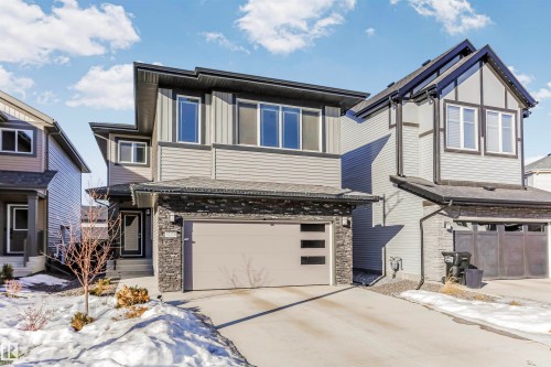 View of front facade featuring a garage, stone siding, and concrete driveway - 3108 158 Street, Edmonton, AB - Outdoor
