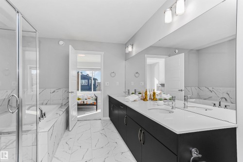 Ensuite bathroom featuring a garden tub, double vanity, light marble finish floors, and a marble finish shower - 3108 158 Street, Edmonton, AB - Indoor Photo Showing Bathroom