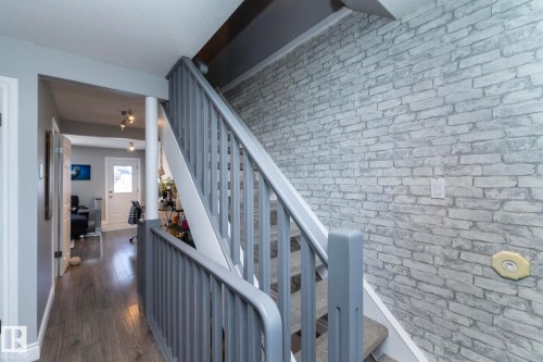 Stairway with wood-type flooring and brick wall - 4371 46 Street, Stony Plain, AB - 