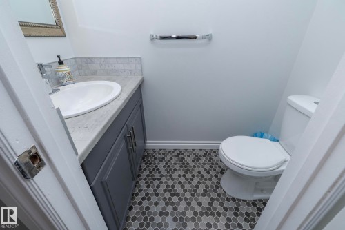 Half bathroom with vanity and dark tile patterned floors - 4371 46 Street, Stony Plain, AB - Indoor Photo Showing Bathroom