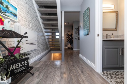Entryway featuring brick wall and dark wood-style floors - 4371 46 Street, Stony Plain, AB - Indoor Photo Showing Other Room