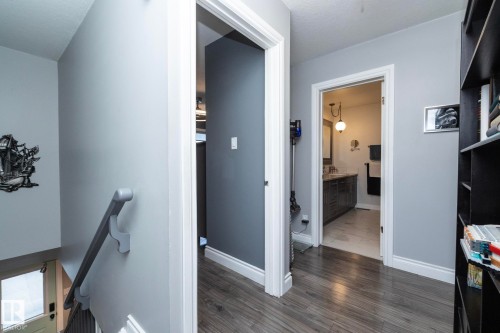 Hall with dark wood finished floors and an upstairs landing - 4371 46 Street, Stony Plain, AB - Indoor Photo Showing Other Room