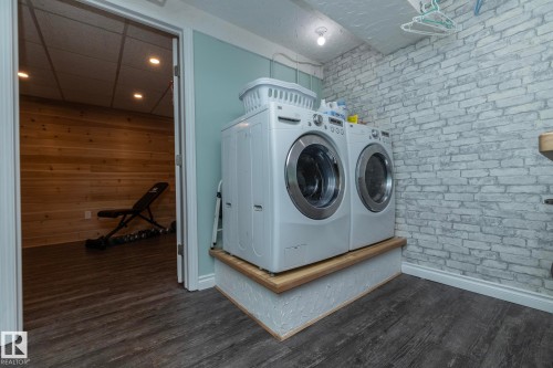 Laundry area with dark wood-type flooring and separate washer and dryer - 4371 46 Street, Stony Plain, AB - Indoor Photo Showing Laundry Room