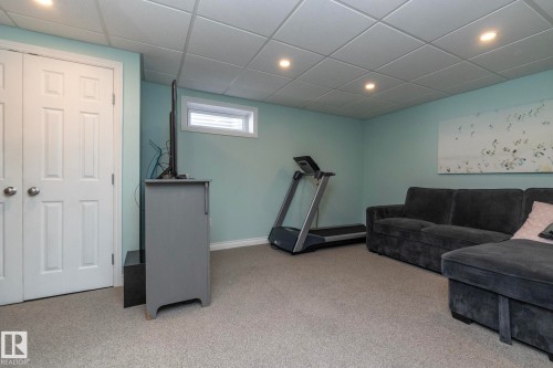 Living area with light carpet, a paneled ceiling, and recessed lighting - 4371 46 Street, Stony Plain, AB - Indoor