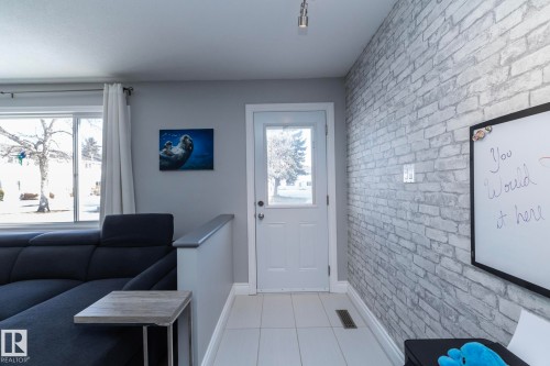 Entryway featuring brick wall and tile patterned floors - 4371 46 Street, Stony Plain, AB - Indoor