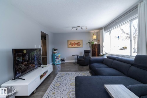 Living room featuring dark wood-style floors and track lighting - 4371 46 Street, Stony Plain, AB - Indoor Photo Showing Living Room