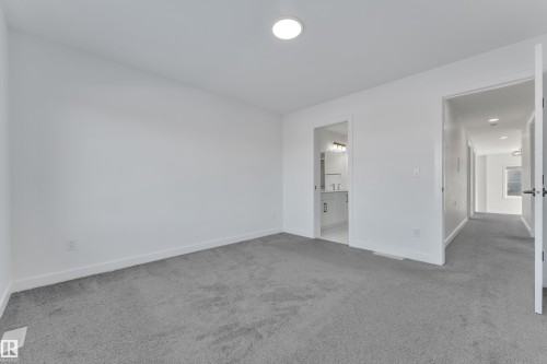 Unfurnished bedroom featuring light colored carpet and ensuite bathroom - 1822 Collip View View, Edmonton, AB - Indoor Photo Showing Other Room