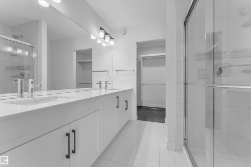 Full bathroom featuring a stall shower, double vanity, a walk in closet, and light tile patterned flooring - 1822 Collip View View, Edmonton, AB - Indoor Photo Showing Bathroom