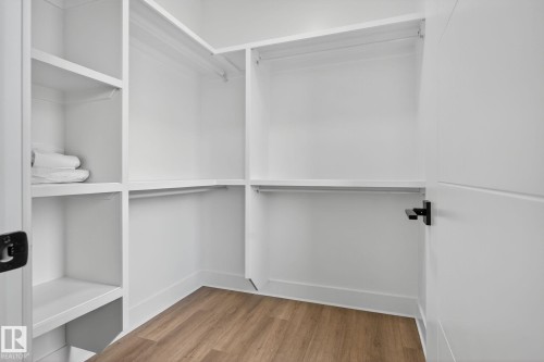 Walk in closet with light wood-type flooring - 456 Crystal Creek Link, Leduc, AB - Indoor With Storage