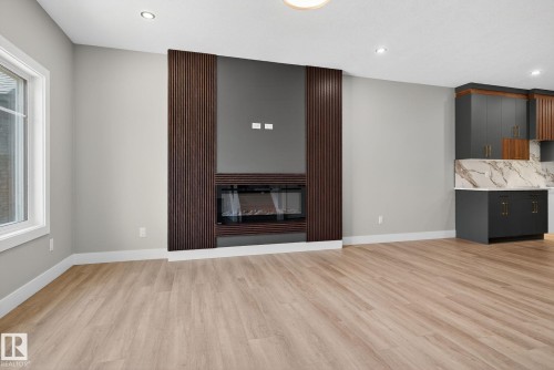 Unfurnished living room with a glass covered fireplace, recessed lighting, and light wood finished floors - 456 Crystal Creek Link, Leduc, AB - Indoor Photo Showing Other Room With Fireplace