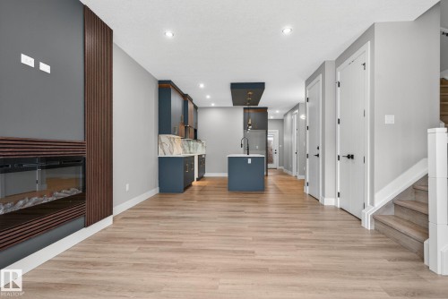 Unfurnished living room featuring light wood-type flooring and recessed lighting - 456 Crystal Creek Link, Leduc, AB - Indoor With Fireplace