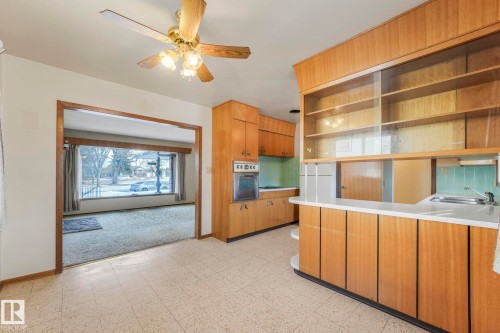 Kitchen with open shelves, a ceiling fan, light countertops, oven, and tasteful backsplash - 10324 42 Street, Edmonton, AB - Indoor Photo Showing Kitchen