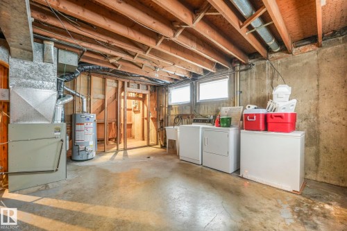 Basement featuring separate washer and dryer, water heater, and heating unit - 10324 42 Street, Edmonton, AB - Indoor Photo Showing Laundry Room