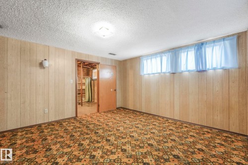 Empty room with wooden walls and a textured ceiling - 10324 42 Street, Edmonton, AB - Indoor Photo Showing Other Room