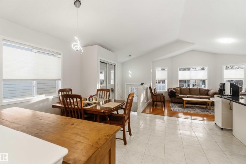 Dining room with healthy amount of natural light, vaulted ceiling, and light tile patterned flooring - 1706 Turvey Bend, Edmonton, AB - Indoor Photo Showing Dining Room