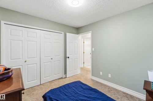 Bedroom featuring light carpet, a textured ceiling, and a closet - 1706 Turvey Bend, Edmonton, AB - Indoor Photo Showing Bedroom