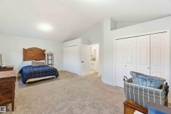 Bedroom with multiple closets, carpet, and lofted ceiling - 