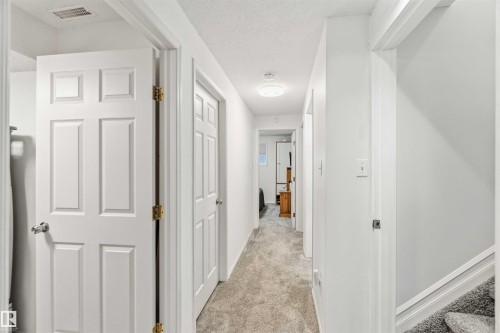 Corridor with light colored carpet and a textured ceiling - 1706 Turvey Bend, Edmonton, AB - Indoor Photo Showing Other Room