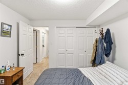 Bedroom with light carpet, a textured ceiling, and a closet - 