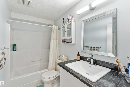 Bathroom featuring vanity, a textured ceiling, and shower / tub combo with curtain - 1706 Turvey Bend, Edmonton, AB - Indoor Photo Showing Bathroom