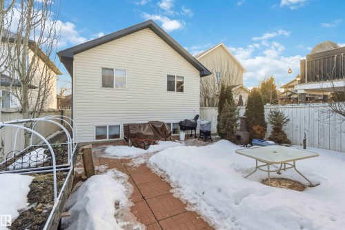 Snow covered back of property featuring a fenced backyard and a patio area - 1706 Turvey Bend, Edmonton, AB - Outdoor With Exterior