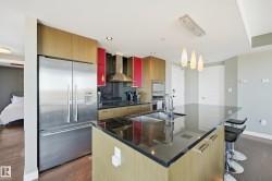 Kitchen featuring stainless steel appliances, modern cabinets, dark wood-type flooring, and pendant lighting - 