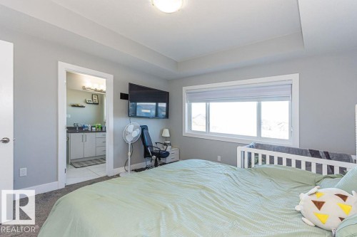 Bedroom featuring carpet floors, ensuite bath, and a raised ceiling - 1224 Mcconachie Boulevard, Edmonton, AB - Indoor Photo Showing Bedroom