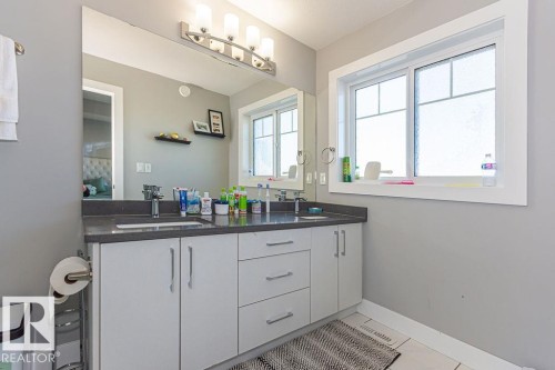 Full bath featuring double vanity and light tile patterned floors - 1224 Mcconachie Boulevard, Edmonton, AB - Indoor Photo Showing Bathroom