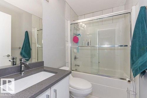 Bathroom featuring bath / shower combo with glass door and vanity - 1224 Mcconachie Boulevard, Edmonton, AB - Indoor Photo Showing Bathroom